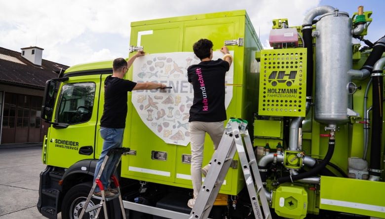 Die Firma „klebundschrift“ ist im Grossraum Zürich tätig und auf Werbetechnik, Folierung, Promotion und Print spezialisiert. (Bild © DieSozialfirma) Zwei Mitarbeiter der Sozialfirma klebundschrift bekleben ein Fahrzeug. Bild (c) Die Sozialfirma