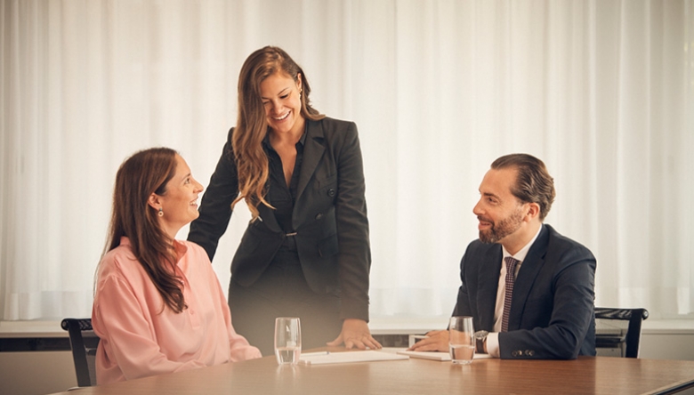 Drei Personen in Business Kleidung sitzen an einem Tisch und reden (Foto © Gian Marco Castelberg)