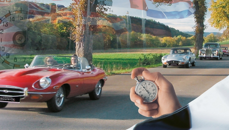 Im Hintergrund sieht man Oldtimer Autos ein Rennen fahren, im Vordergrund eine Hand die eine Stoppuhr hält (Foto: automotive experience gmbh)