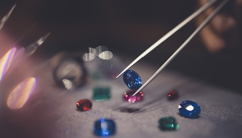 Zu den Steinen, die sich am besten für Investitionen eignen, zählen Rubin, Saphir und Smaragd. (Bild © The Natural Gem) Foto von einer Pinzette die einen Edelstein aufhebt (Bild © The Natural Gem)