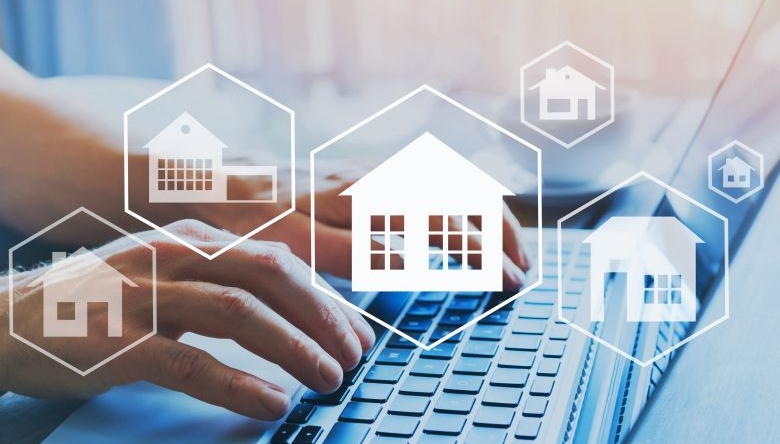 Co-Working Spaces rücken 2019 in den Fokus von Investoren. (Foto: iStock / Getty Images Plus/anyaberkut) Immobilien-Icons im Vordergrund, zwei Hände auf einer Computertastatur im Hintergrund