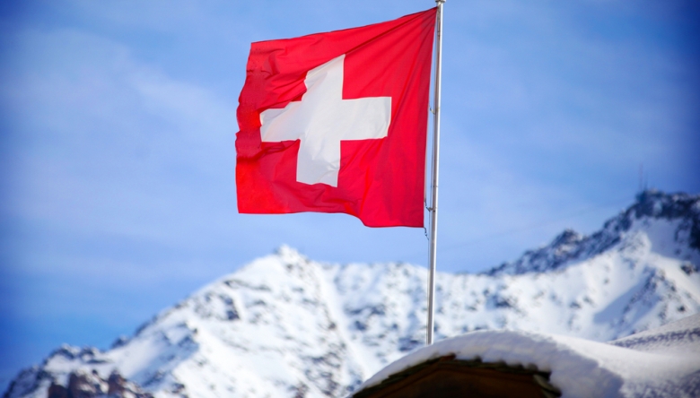 Schweizer Fahne auf Bergspitze weht im Wind C Shutterstock