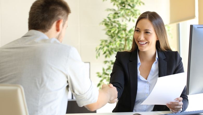 Mann und Frau bei Jobinterview schütteln Hände