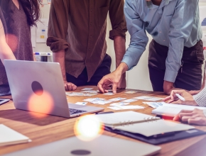 Junge Menschen gemeinsam über einen Tisch mit Aufzeichnungen gebeugt. (Bild © Adobe Stock/Yingyaipumi)