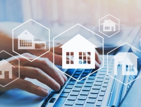 Co-Working Spaces rücken 2019 in den Fokus von Investoren. (Foto: iStock / Getty Images Plus/anyaberkut) Immobilien-Icons im Vordergrund, zwei Hände auf einer Computertastatur im Hintergrund